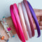 Set of colorful hair ties on a wrist with a plain background